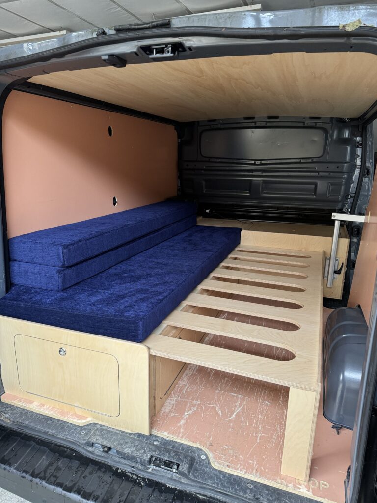 Banquette lit peigne installé dans un Renault Trafic avec aménagement amovible