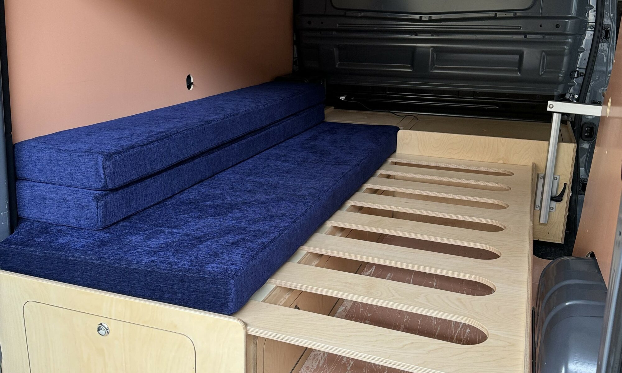 Banquette lit peigne installé dans un Renault Trafic avec aménagement amovible
